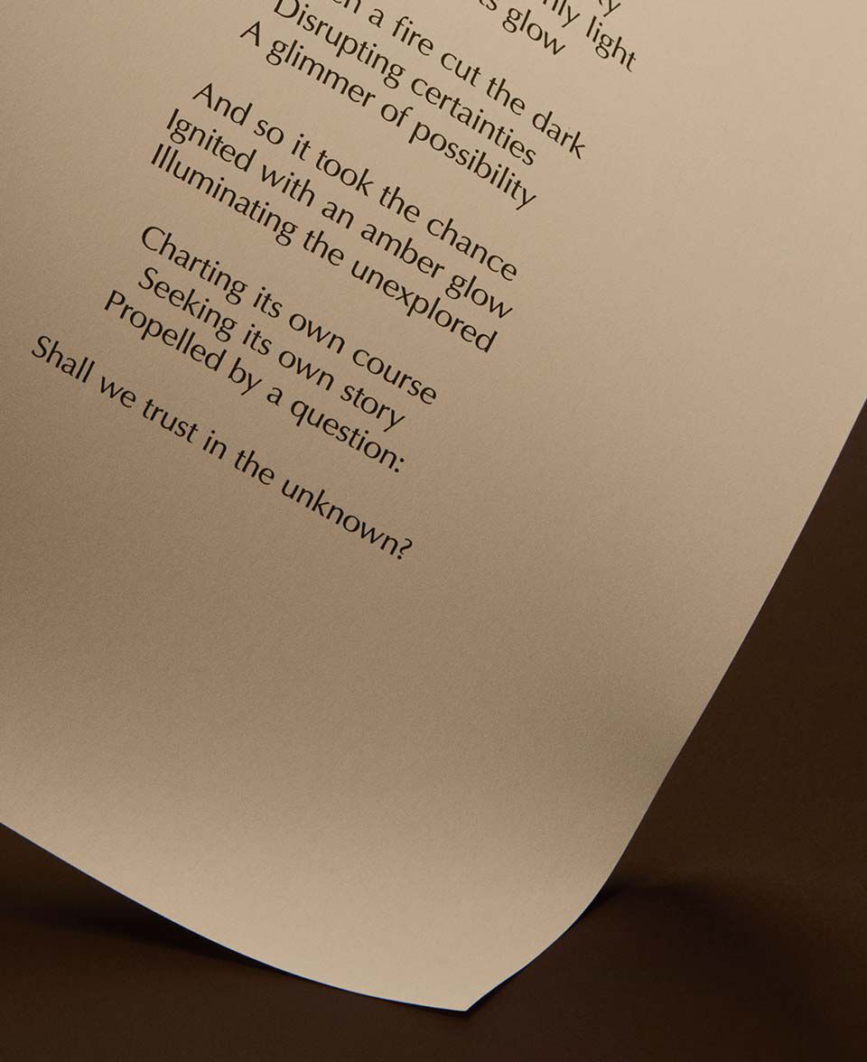 Page incurvee ornee de texte poetique imprime, sur fond brun fonce aux tonalites chaudes.