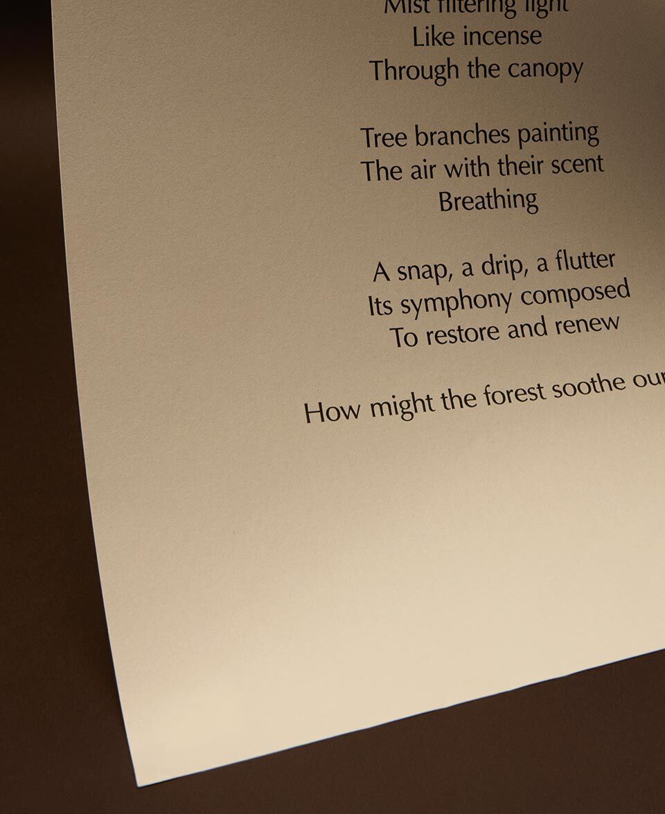 Feuille de papier creme portant un poeme, doucement eclairee sur un fond de tons brun fonce.
