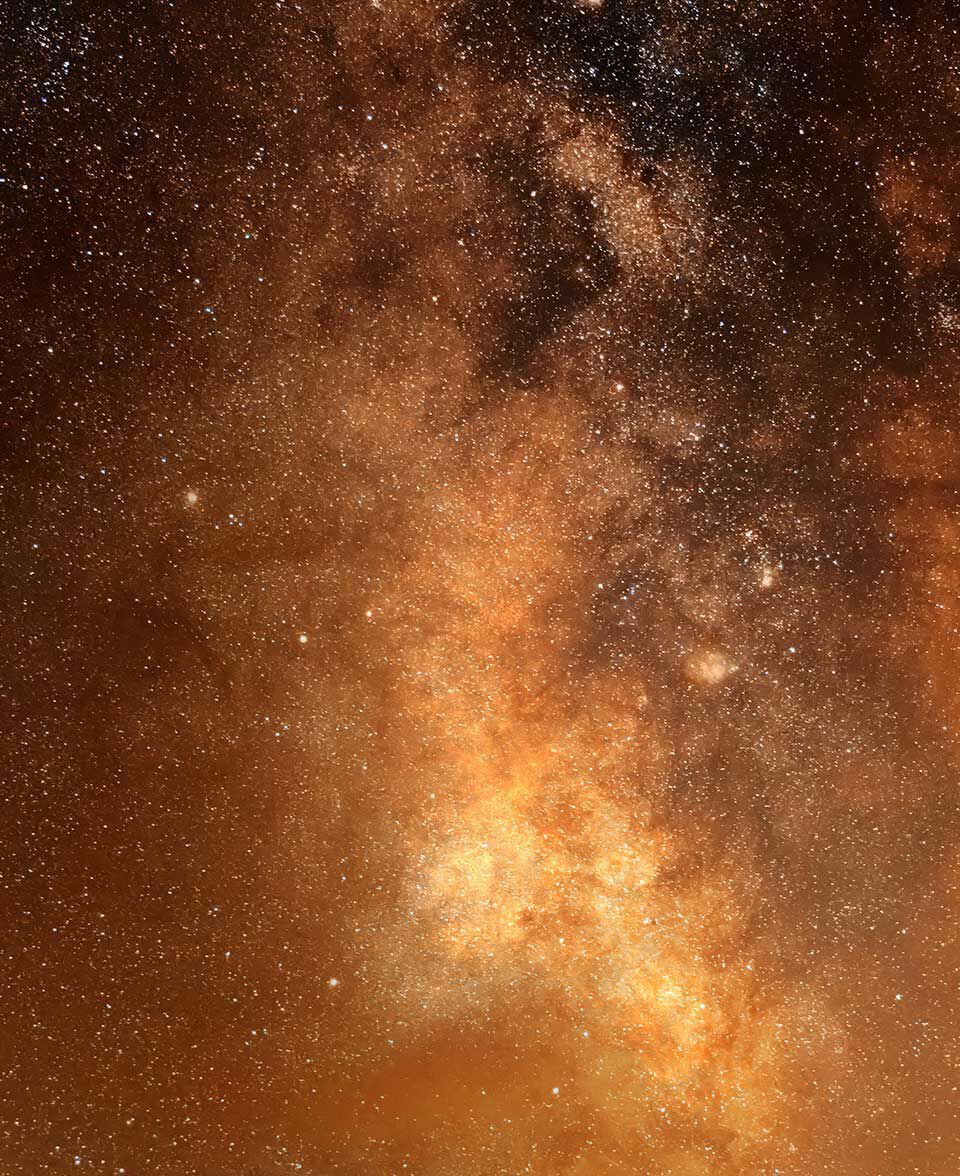 Champ d’etoiles dense aux tons ambres et dores, dans l’etendue du ciel nocturne.