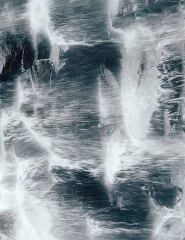 Surface rocheuse bleu gris fonce, parcourue de veines blanches et d’une texture minerale brute, formant un motif marbre tres contraste.